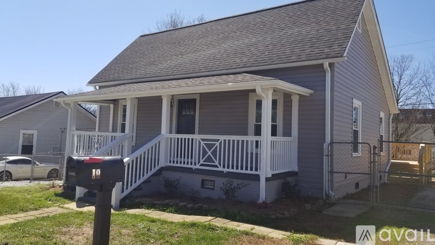 A house with a grey exterior and a white porch.
