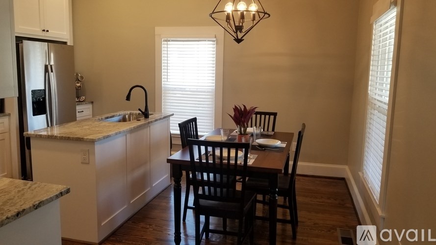 A kitchen with a table and chairs in front of a window.