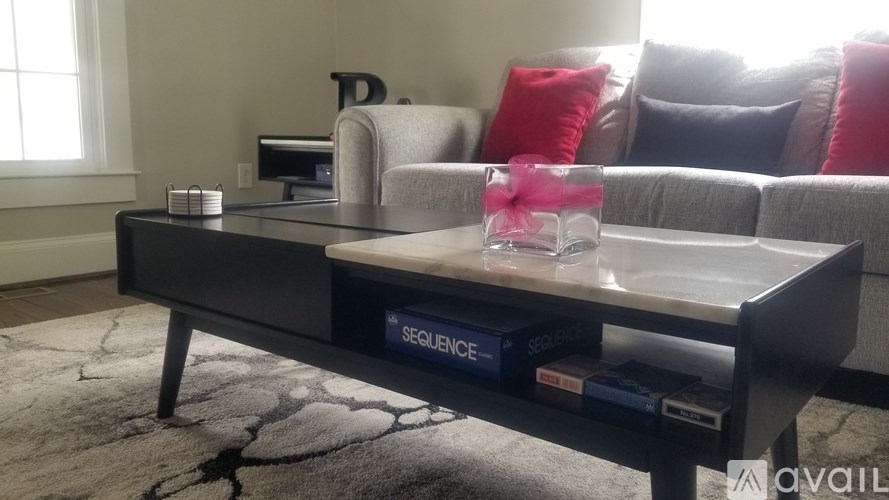 A black coffee table with a box of sequenge on top of it.