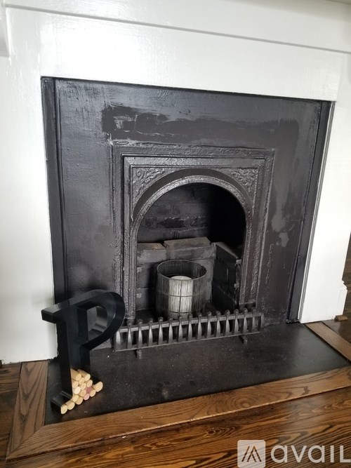 A black fireplace with a fire burning inside.