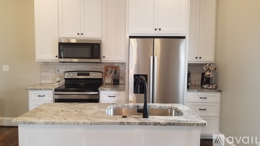 A kitchen with a marble countertop and stainless steel appliances.