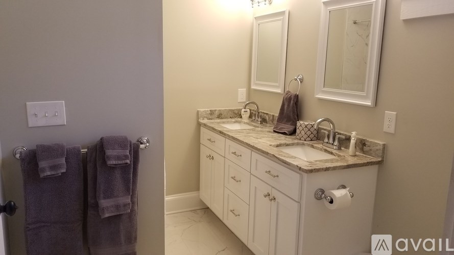 A bathroom with a white vanity and a mirror above it.