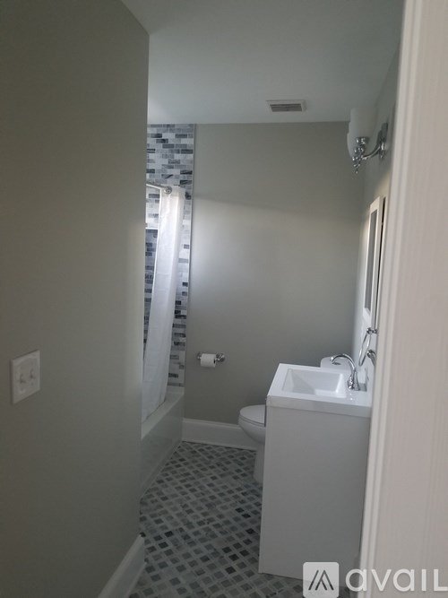 A bathroom with a toilet, sink, and shower.