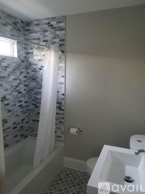 A bathroom with a shower curtain and a toilet.