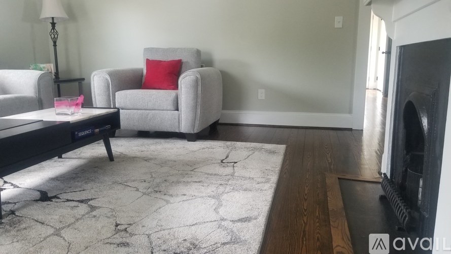 A living room with a grey couch, a coffee table, and a rug.