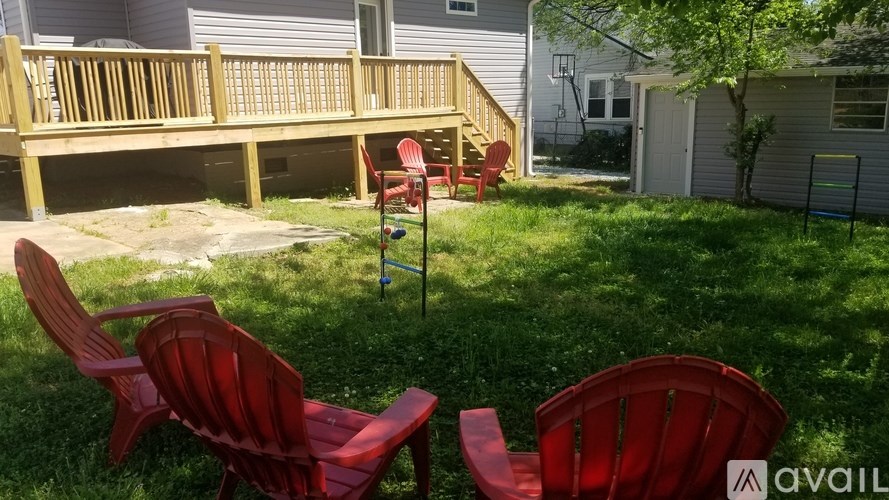 A patio with red chairs and a wooden deck.