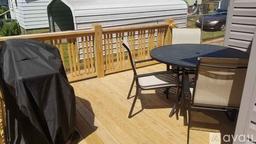 A patio with a table and chairs is covered with a black tarp.