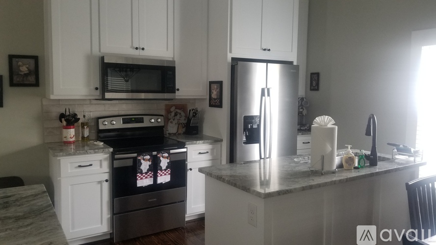 A kitchen with white cabinets and a granite countertop.