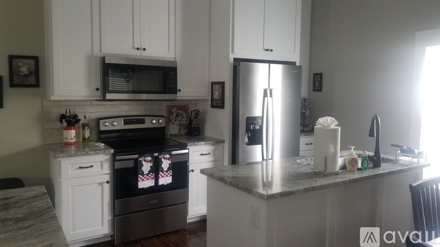 A kitchen with white cabinets and a granite countertop.