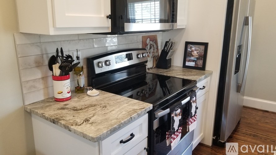 A kitchen with a granite countertop and a fridge.
