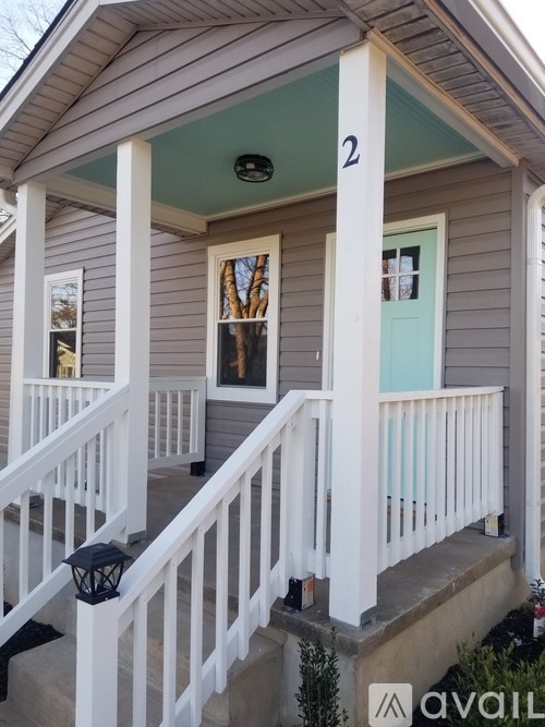 A house numbered 2 has a white porch.