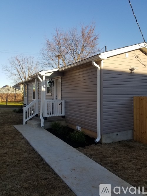 A house with a porch and a walkway leading to it.