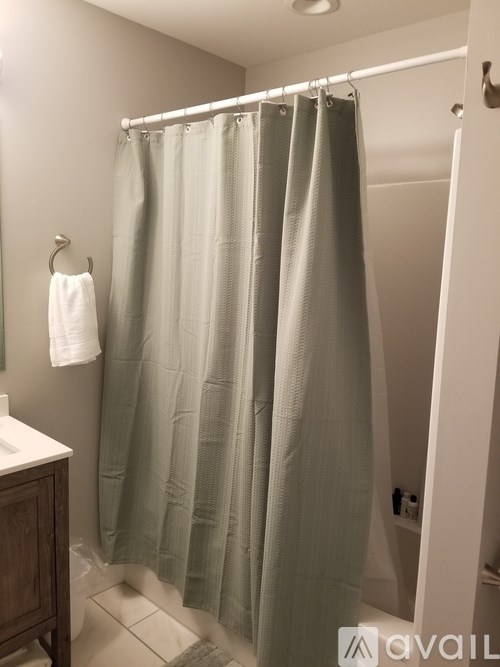 A bathroom with a white towel hanging on a hook.