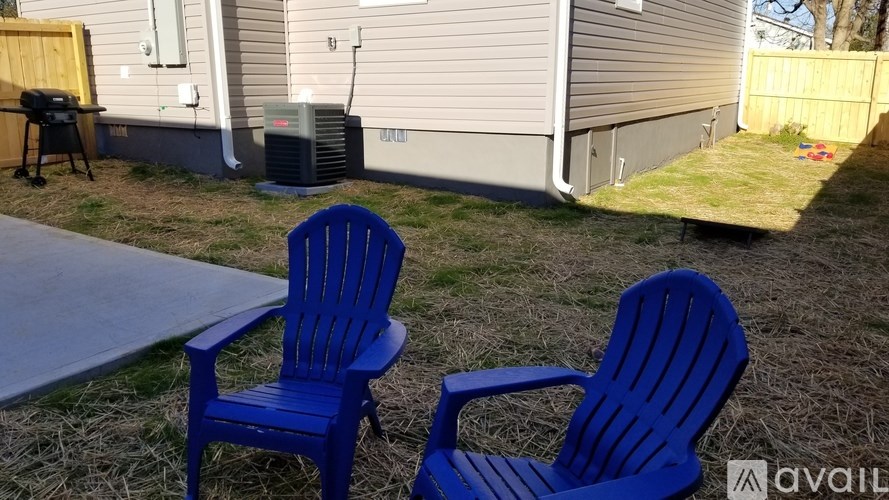 Two blue chairs are placed on a lawn.