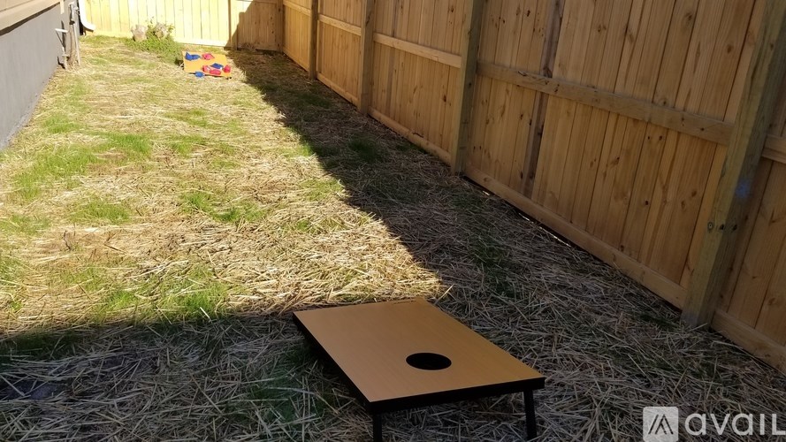 A wooden table with a hole in the middle is placed on a grassy area.