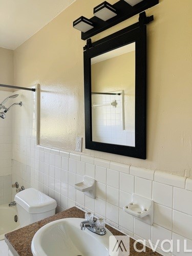 A bathroom with a sink, mirror, and toilet.