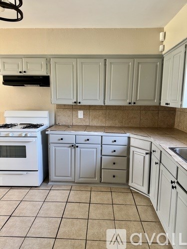 A kitchen with white appliances and cabinets.