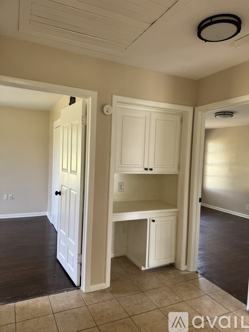 A kitchen area with a white cabinet and a white door.