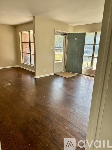 A room with wooden floors and a green door.