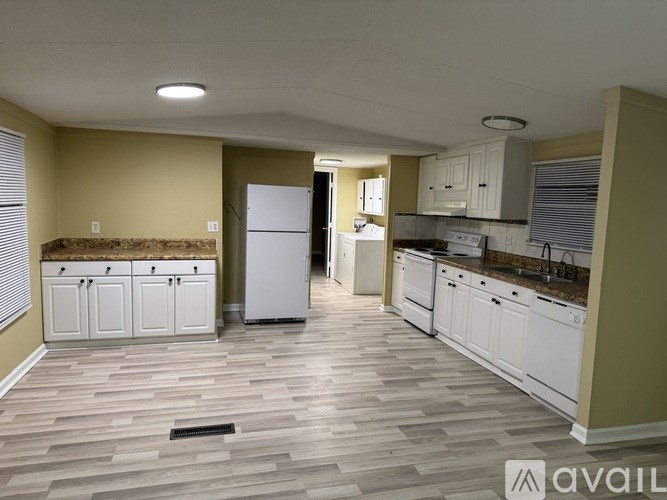 A kitchen with a refrigerator, cabinets, and a countertop.