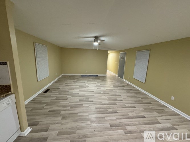 A room with a ceiling fan and tile flooring.