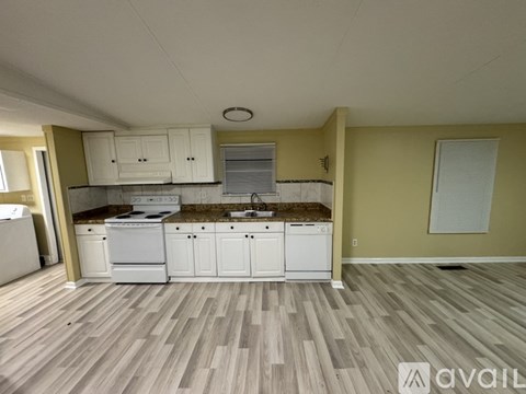 A kitchen with white appliances and cabinets is available for rent.