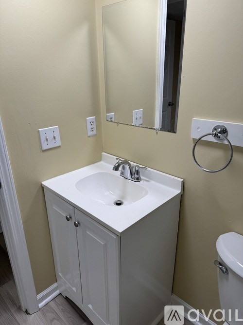 A bathroom with a sink, mirror, and toilet.