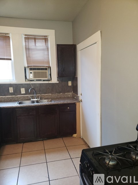 A kitchen with dark wood cabinets and a white fridge.