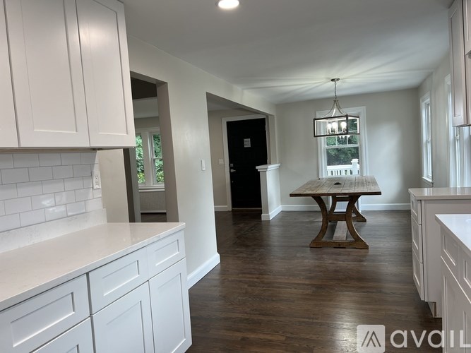 A kitchen with white cabinets and a wooden table.