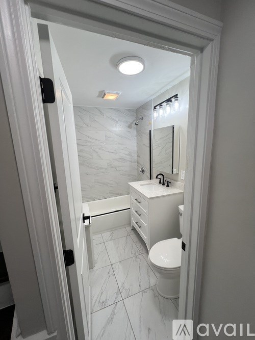 A bathroom with a toilet, sink, and mirror.