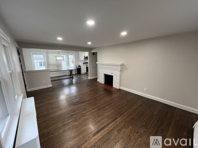 A spacious living room with wood flooring and a fireplace.