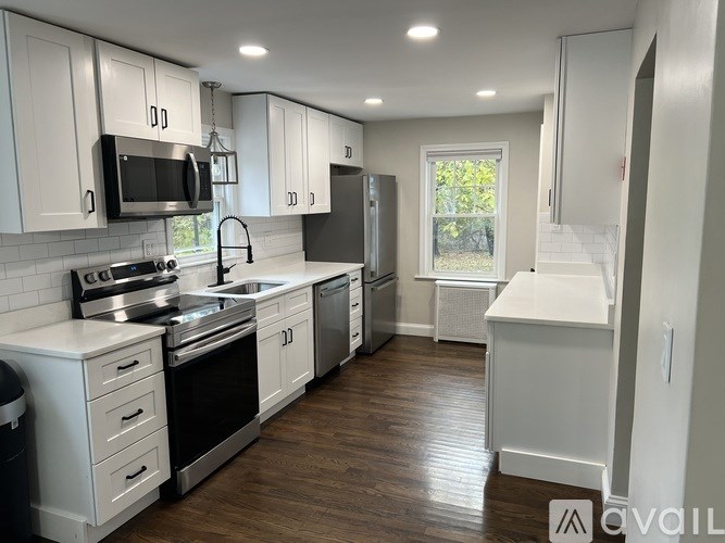 A modern kitchen with white cabinets and stainless steel appliances.