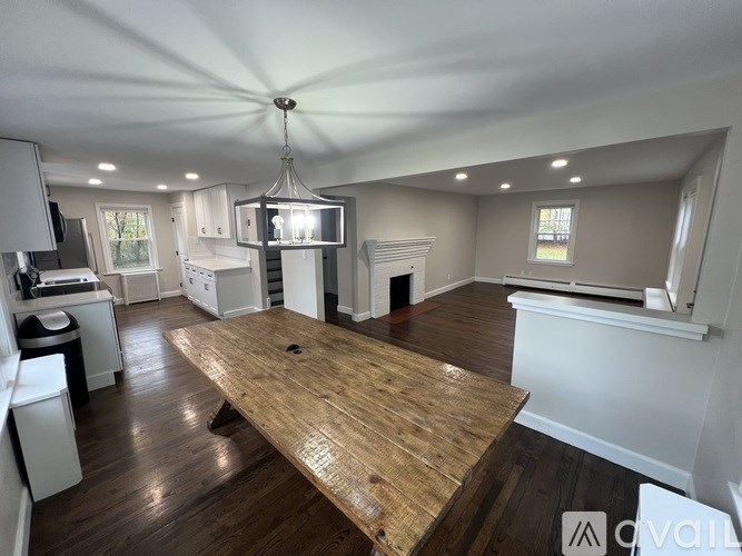 A large wooden table is in the middle of a spacious kitchen and dining area.