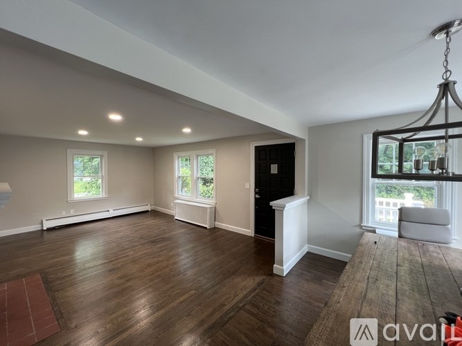 A large, empty room with wooden floors and a chandelier.