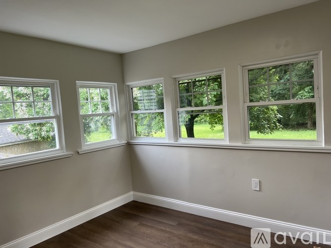 Three windows in a room with wood floors and white walls.