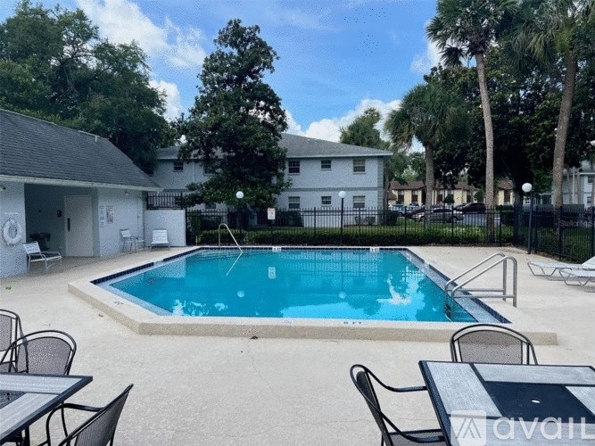 A pool surrounded by chairs and tables is available for use.