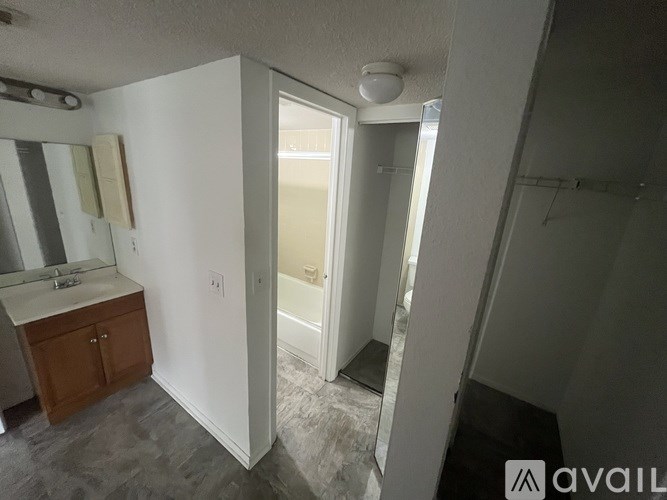 A bathroom with a sink, mirror, and shower.