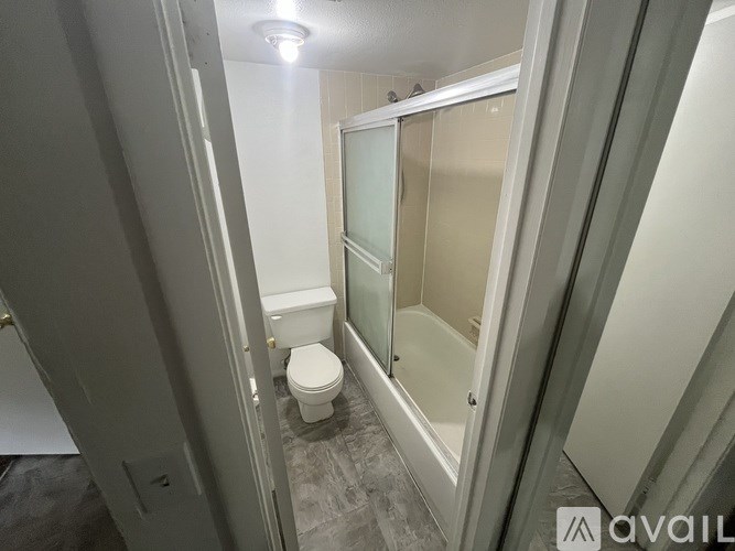 A bathroom with a toilet and a glass shower door.