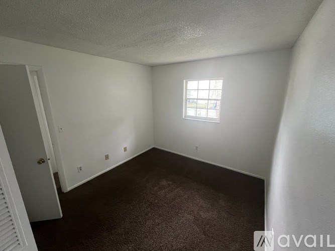 A room with a carpeted floor and a window.