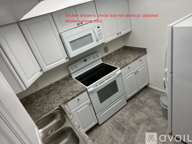 A kitchen with white cabinets and a granite countertop.