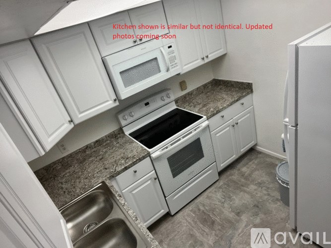 A kitchen with white cabinets and a granite countertop.