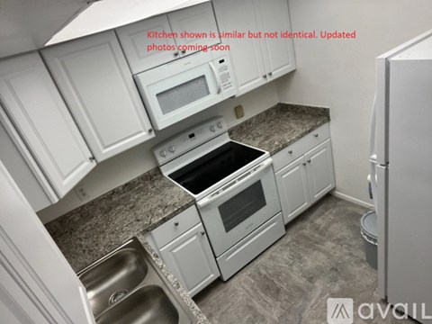 A kitchen with white cabinets and a granite countertop.