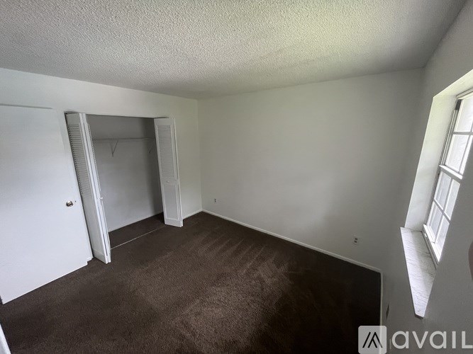 A room with a brown carpet and a white door.