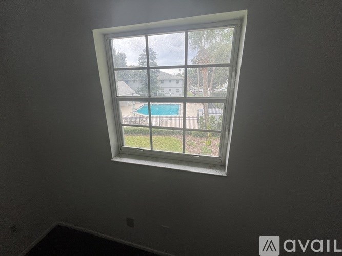A window with a view of a pool and a house.