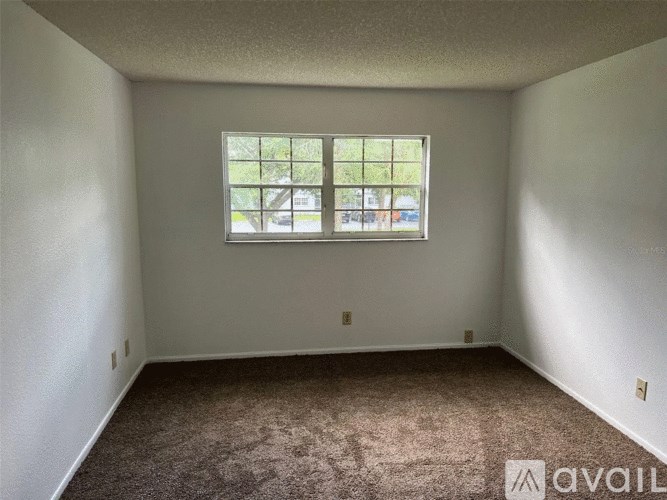 A room with a carpeted floor and a window.