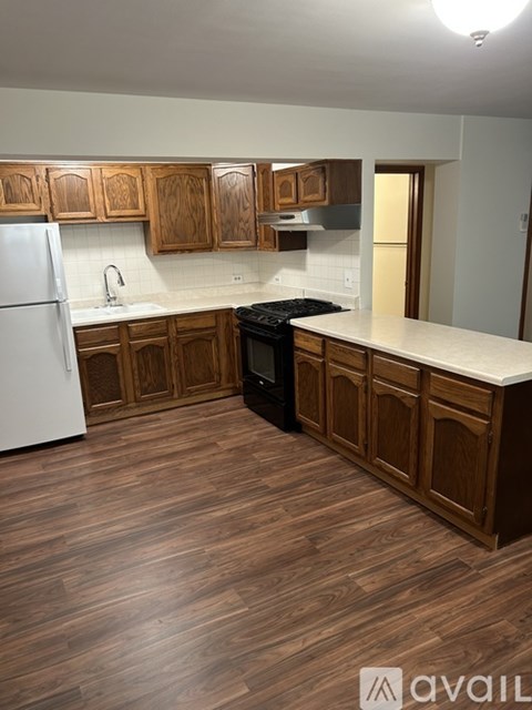 A kitchen with wooden cabinets and a white fridge.