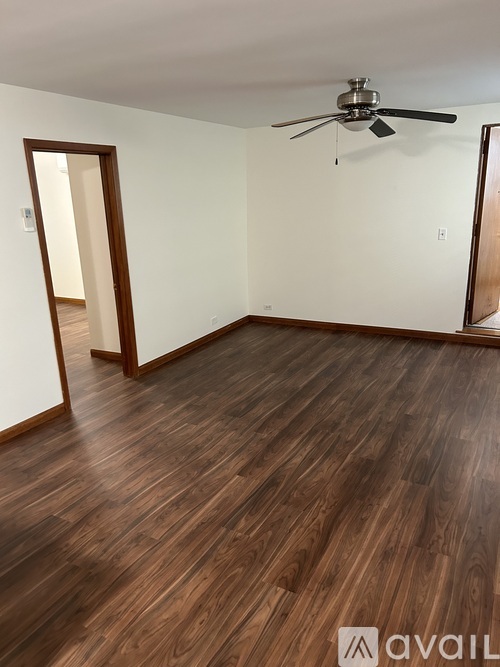 A room with wooden flooring and a ceiling fan.