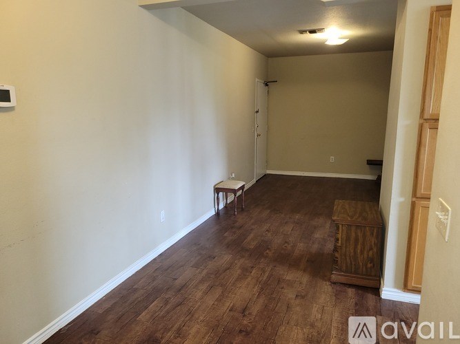 A room with wooden flooring and a single chair.