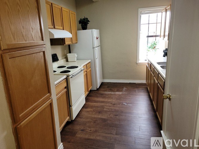 A kitchen with wooden cabinets and a white stove top oven.