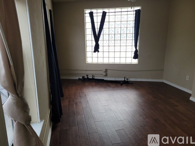 A room with a window and wooden flooring.